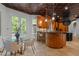 Eat-in kitchen featuring a glass table, breakfast bar, custom cabinets, and access to the outdoor deck at 417 Swans Mill Xing, Raleigh, NC 27614