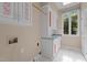 Functional laundry room with white cabinets, sink, washer/dryer hookups, and window for natural light at 417 Swans Mill Xing, Raleigh, NC 27614