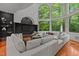 Bright living room with large windows offering a view of the surrounding trees and a large comfy sectional at 417 Swans Mill Xing, Raleigh, NC 27614