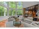 Living room with fireplace and large windows offering a scenic view of the outdoor greenery and wooded space at 417 Swans Mill Xing, Raleigh, NC 27614