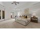 Bright main bedroom features a tray ceiling, ceiling fan, sitting area, and large windows at 417 Swans Mill Xing, Raleigh, NC 27614