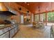 Covered outdoor kitchen area, featuring a grill, dining table, and stylish brick accents at 417 Swans Mill Xing, Raleigh, NC 27614