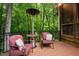 Comfortable outdoor seating area with a patio heater and views of the wooded landscape beyond at 417 Swans Mill Xing, Raleigh, NC 27614
