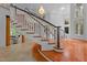 Elegant curved staircase with wood treads, black accents, and view to a sitting area at 417 Swans Mill Xing, Raleigh, NC 27614