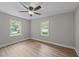 Bedroom with new wood-look flooring boasts bright windows and ceiling fan, for a comfortable living space at 423 N Main St, Wendell, NC 27591