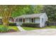 Attractive single-story home with gray siding, lush landscaping, and a cozy, covered front porch at 423 N Main St, Wendell, NC 27591