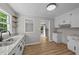 Updated kitchen features white cabinets, granite countertops and stainless steel double sink and new wood-look flooring at 423 N Main St, Wendell, NC 27591