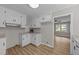 View of renovated kitchen features white cabinets, granite countertops and stainless steel appliances, adjacent to living space at 423 N Main St, Wendell, NC 27591