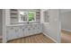 Updated kitchen features white cabinets and granite countertops, open shelving, and stainless steel sink beneath a bright window at 423 N Main St, Wendell, NC 27591