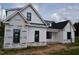 Modern farmhouse exterior featuring white siding, black trim, and a gabled roof under construction at 4330 Medicus Ln, Franklinton, NC 27525