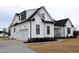 Exterior elevation featuring a modern farmhouse design with attached garage, white siding, and black accents at 4330 Medicus Ln, Franklinton, NC 27525