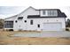 Side exterior elevation of a white two-story home featuring an attached garage and screened-in back porch at 4330 Medicus Ln, Franklinton, NC 27525