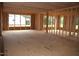 Unfinished room framed with wooden studs, large windows, and plywood flooring, awaiting customization at 4330 Medicus Ln, Franklinton, NC 27525