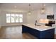 Bright kitchen with a navy island, white cabinets, stainless steel appliances, and modern pendant lighting at 4330 Medicus Ln, Franklinton, NC 27525