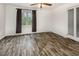 Bright bedroom showcasing elegant wood flooring, a ceiling fan, and natural light from a large window at 5013 Dunwoody Trl, Raleigh, NC 27606