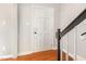 Hallway featuring hardwood floors, light gray walls, white door and black stair railing at 5013 Dunwoody Trl, Raleigh, NC 27606
