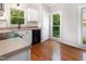 Well-lit kitchen features white cabinets, tile backsplash and stainless steel appliances, view to yard at 5013 Dunwoody Trl, Raleigh, NC 27606
