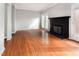 Bright living room featuring hardwood floors and a classic black fireplace, next to the French door at 5013 Dunwoody Trl, Raleigh, NC 27606
