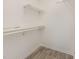 Bright walk-in closet with wood-look tile flooring and shelving with poles for optimal storage convenience at 5013 Dunwoody Trl, Raleigh, NC 27606