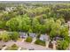 An aerial view reveals homes nestled among lush, green trees in a vibrant neighborhood at 5033 Knightsbridge Way, Raleigh, NC 27604