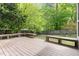 A spacious wooden deck with built-in benches overlooks a large, fenced-in backyard with mature trees at 5033 Knightsbridge Way, Raleigh, NC 27604