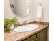 Stylish bathroom vanity featuring a granite countertop, modern faucet, and decorative mirror at 5033 Knightsbridge Way, Raleigh, NC 27604