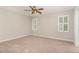 Comfortable bedroom featuring neutral carpet, a ceiling fan, and bright windows with custom shutters at 5033 Knightsbridge Way, Raleigh, NC 27604