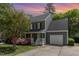 Charming two-story home with gray siding, a white porch, a two car garage and well-manicured landscaping at 5033 Knightsbridge Way, Raleigh, NC 27604