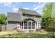 Rear view of a two-story home with a screened-in porch and a large deck, surrounded by a green lawn at 5033 Knightsbridge Way, Raleigh, NC 27604