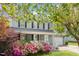 Charming gray home with a welcoming front porch and vibrant pink and white azaleas in the front yard at 5033 Knightsbridge Way, Raleigh, NC 27604