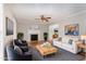 Bright living room with hardwood floors, fireplace, ceiling fan, and neutral-toned furniture at 5033 Knightsbridge Way, Raleigh, NC 27604