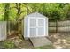 A small, gray shed with a wooden ramp and double doors is located in the backyard at 5033 Knightsbridge Way, Raleigh, NC 27604