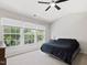 Bright bedroom with three large windows, a ceiling fan, and neutral carpeting at 5044 Brooke Lauren Ln, Raleigh, NC 27616