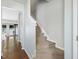 Bright hallway with hardwood floors transitioning to a carpeted staircase with white trim at 5044 Brooke Lauren Ln, Raleigh, NC 27616