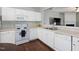 Well-lit kitchen with white cabinetry, laminate countertops, and an open view to the living room at 5044 Brooke Lauren Ln, Raleigh, NC 27616