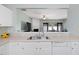 Bright kitchen featuring white cabinets, laminate counters, and a window to the living area at 5044 Brooke Lauren Ln, Raleigh, NC 27616