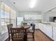 Eat-in kitchen with white cabinets and essential appliances, complemented by a wooden dining set at 5044 Brooke Lauren Ln, Raleigh, NC 27616