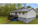Exterior showcasing a rear deck with stairs and durable metal roof on a home surrounded by lush greenery at 5064 Murrell Dr, Oxford, NC 27565