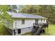 Back exterior featuring a wooden deck with stairs and a robust metal roof, ideal for outdoor relaxation at 5064 Murrell Dr, Oxford, NC 27565