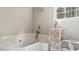 A bathtub view showcasing fixtures and a decorative storage system by the window at 5064 Murrell Dr, Oxford, NC 27565