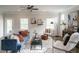 Bright living room with a stylish blue couch, ceiling fan, and large windows at 52 E American Marigold Dr # 63, Benson, NC 27504
