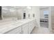 Bright bathroom featuring a double sink vanity, large mirror, and a view into the walk-in closet and shower at 5616 Horsewalk Cir, Raleigh, NC 27606