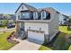 Charming two-story home featuring a white garage door, stone accents, and an inviting entryway at 5616 Horsewalk Cir, Raleigh, NC 27606