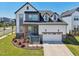 Beautiful two-story home featuring a white garage door, stone accents, a landscaped yard, and an inviting entryway at 5616 Horsewalk Cir, Raleigh, NC 27606