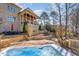 Beautiful backyard featuring a stone paver patio, hot tub, mature trees, and lush landscaping at 595 Legacy Falls N Dr, Chapel Hill, NC 27517