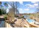 Expansive backyard showcasing a hot tub, stone patio, and serene lake views at 595 Legacy Falls N Dr, Chapel Hill, NC 27517