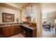 A convenient in-home bar area features stone countertops, wood cabinets and is situated beside a casual dining area at 595 Legacy Falls N Dr, Chapel Hill, NC 27517