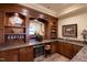 A beautiful home bar with wood trim, stone countertops, wine fridge, and ample glassware storage at 595 Legacy Falls N Dr, Chapel Hill, NC 27517