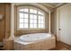 Bright bathroom with a tiled, elevated soaking tub situated beneath a large window at 595 Legacy Falls N Dr, Chapel Hill, NC 27517