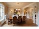 Light-filled dining room with an elegant chandelier, seating for eight, and a sunlit window at 595 Legacy Falls N Dr, Chapel Hill, NC 27517